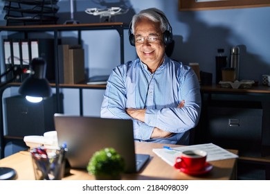 Hispanic Senior Man Wearing Call Center Agent Headset At Night Happy Face Smiling With Crossed Arms Looking At The Camera. Positive Person. 