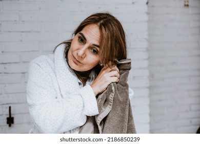 Hispanic Senior Middle Aged Woman Sitting On The Bathtub Corner Wiping Her Hair With Towel In Mexico Latin America