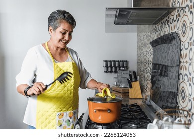 Hispanic senior woman cooking in her kitchen at home in Mexico Latin America
 - Powered by Shutterstock