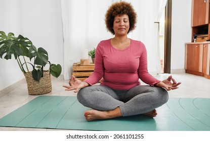 Hispanic Senior Woman Doing Yoga Session At Home - Focus On Face