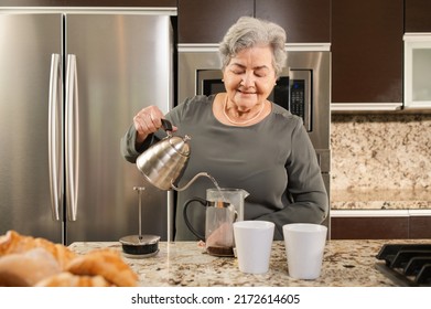 Hispanic Senior Woman Making Coffee In The Kitchen. 