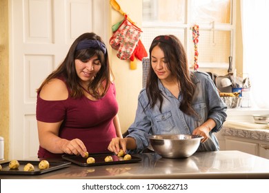 Hispanic Sisters Making Chocolate Chip Cookies While Having Fun - Women Cooking Homemade Cookies - Home Activities