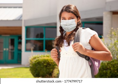 Hispanic Student Girl Wearing Face Mask With Backpack On School Campus.