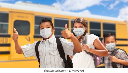 Hispanic Students Near School Bus Wearing Face Masks.