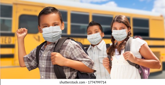 Hispanic Students Near School Bus Wearing Face Masks.