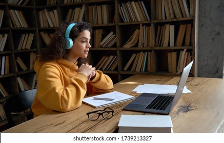 Hispanic Teen Girl, Latin Young Woman School College Student Wear Headphones Learn Watching Online Webinar Webcast Class Looking At Laptop Elearning Distance Course Or Video Calling Remote Teacher.