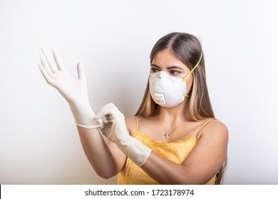 Hispanic Teen Putting On Gloves Wearing A Face Mask