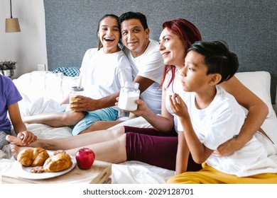 Hispanic Teenage Girl With Cerebral Palsy And Her Family Having Breakfast On Bed At Home, In Disability Concept In Latin America