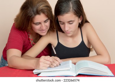 Hispanic Teenage Girl Studying With Her Mother At Home