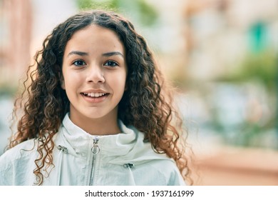 Hispanic teenager girl smiling happy standing at the city.