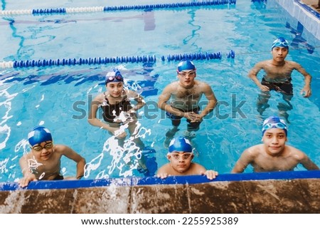 hispanic teenagers team of swimmers wearing cap and goggles in a swimming training at the Pool in Mexico Latin America