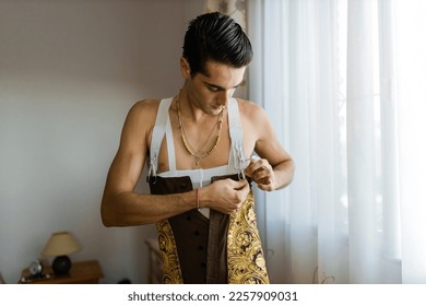 Hispanic torero tying traditional garment