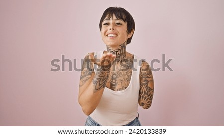 Hispanic woman with amputee arm smiling confident blowing kiss over isolated pink background 商業照片 © 