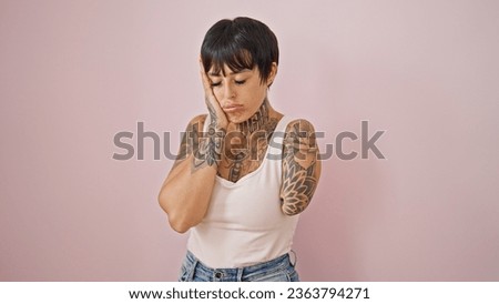 Hispanic woman with amputee arm stressed standing over isolated pink background
