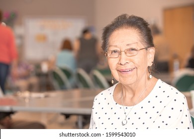 Hispanic Woman In A Busy Senior Center