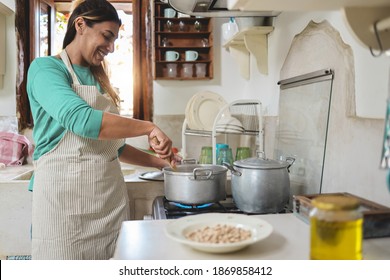 Hispanic Woman Cooking Inside Vintage Kitchen At Home - Focus On Hand