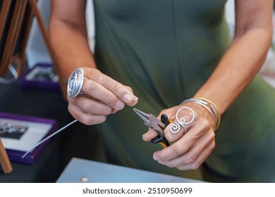 Hispanic Woman Crafting Earrings at Her Street Stall Selling Handmade Aluminum Wire Jewelry  - Powered by Shutterstock