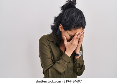 Hispanic Woman With Dark Hair Standing Over Isolated Background With Sad Expression Covering Face With Hands While Crying. Depression Concept. 
