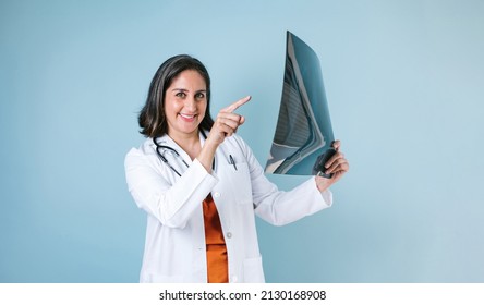 hispanic woman doctor looks at xray radiography images in radiology clinic on blue background in Mexico Latin America