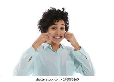 Hispanic Woman Doing Facial Expression, Giving Herself A Pinch On Cheek To Smile While Looking At Camera On White Background