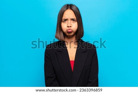 hispanic woman with a goofy, crazy, surprised expression, puffing cheeks, feeling stuffed, fat and full of food