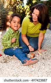 Hispanic Woman And Her Son Playing Outside Together.