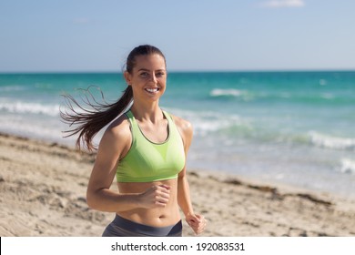 Hispanic Woman Jogging On The Beach