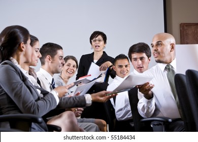 Hispanic woman leading diverse group of young business people in training seminar - Shutterstock ID 55184434
