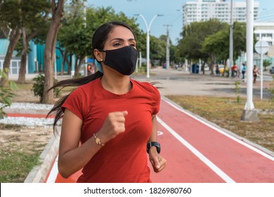 Hispanic Woman With A Mask Running Through The Park. Healthy Lifestyle