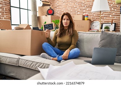 Hispanic Woman Moving To A New Home Thinking Attitude And Sober Expression Looking Self Confident 