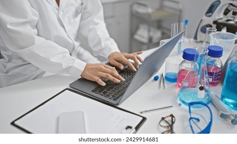 Hispanic woman scientist's hands deftly typing, immersed in groundbreaking medical research, working indoors at a bustling lab using laptop computer. - Powered by Shutterstock