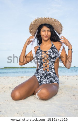 Hispanic woman sitting on sand beach. Brazilian culture