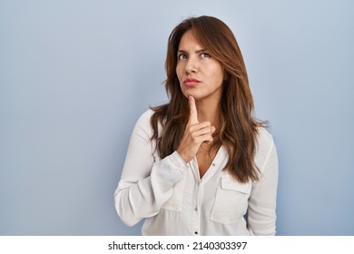 Hispanic Woman Standing Over Isolated Background Thinking Concentrated About Doubt With Finger On Chin And Looking Up Wondering 