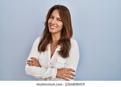 Hispanic woman standing over isolated background happy face smiling with crossed arms looking at the camera. positive person.  - Powered by Shutterstock