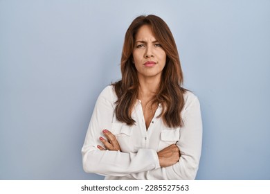 Hispanic woman standing over isolated background skeptic and nervous, disapproving expression on face with crossed arms. negative person.  - Shutterstock ID 2285527563