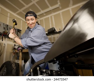 Hispanic Woman Swinging A Sledgehammer At A Motorcycle