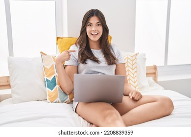 Hispanic Woman Using Computer Laptop On The Bed Pointing Finger To One Self Smiling Happy And Proud 