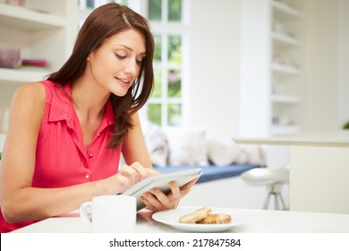 Hispanic Woman Using Digital Tablet In Kitchen At Home - Powered by Shutterstock