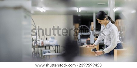 Hispanic woman wearing work clothes working in a distribution warehouse