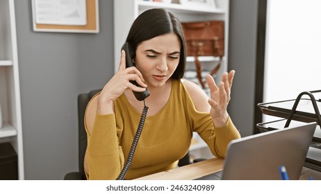 Hispanic woman working in office on phone call showing frustration - Powered by Shutterstock