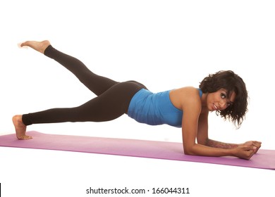 An Hispanic Woman Working Out Doing Plank With One Leg Up.