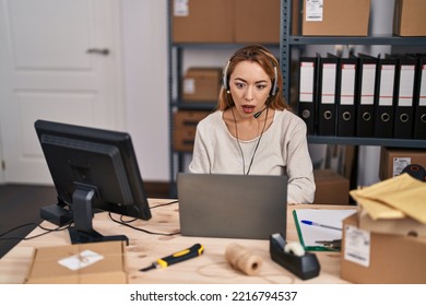 Hispanic Woman Working At Small Business Ecommerce Wearing Headset Scared And Amazed With Open Mouth For Surprise, Disbelief Face 