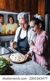 Hispanic Women Family Grandmother, Mother And Granddaughter Cooking At Home At Kitchen In Mexico Latin America