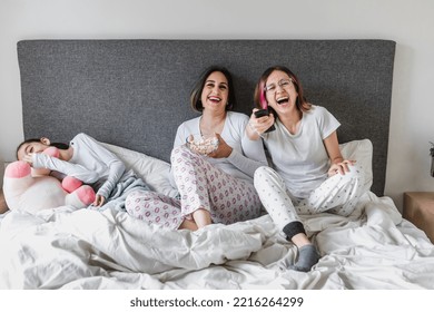 Hispanic Women Family Watching A Tv And Movie On Bed Together Mother And Daughters In Mexico Latin America	