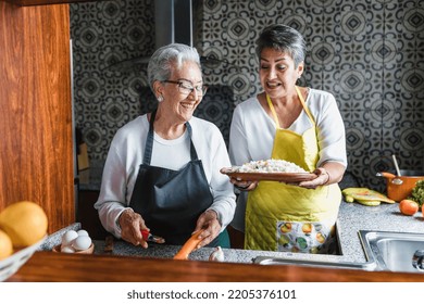 Hispanic Women Grandmother And Adult Daughter Cooking At Home Kitchen In Mexico Latin America