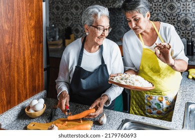 Hispanic Women Grandmother And Daughter Cooking At Home Kitchen In Mexico Latin America