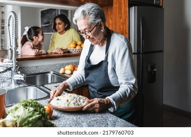 Hispanic Women Grandmother And Granddaughter Cooking At Home Kitchen In Mexico Latin America