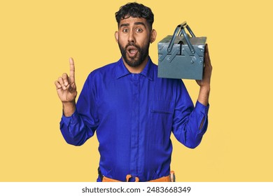 Hispanic worker with toolbox in studio having some great idea, concept of creativity.