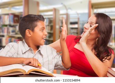 Hispanic Young Boy And Famle Adult High Five Whilte Studying At Library.