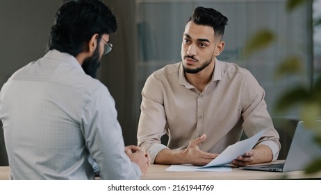 Hispanic young businessman man financial advisor agent lawyer worker consulting unknown male client customer explaining insurance contract benefits negotiating giving business advice at office meeting - Shutterstock ID 2161944769